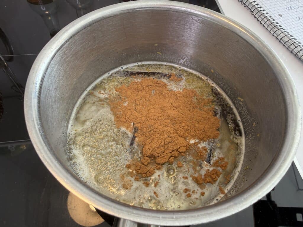 Vand, sukker, citron, vanilje og kanel der koger.