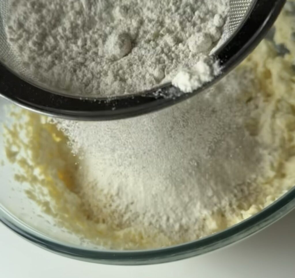 Mel sigtes i skål med smørcreme